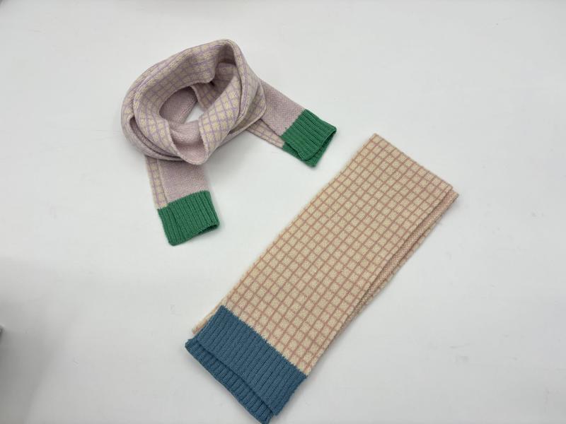 Two knitted plaid scarves: lavender with green cuffs looped, and beige with blue ribbed cuff folded flat on white surface