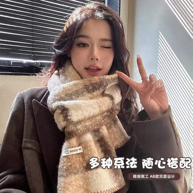 Young woman wearing a cozy beige and brown plaid fuzzy knit scarf with double-sided design, styled over a dark wool coat indoors