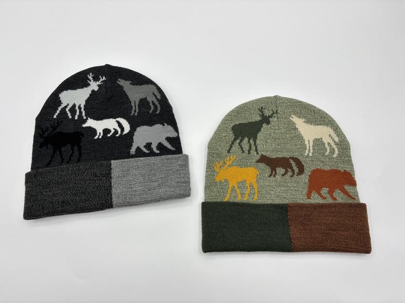 Two knit beanies with jacquard wildlife animal patterns showing deer, moose, wolf, and bear silhouettes in charcoal and sage green colorways