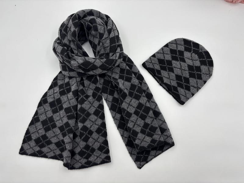 Grey and black argyle diamond pattern knit scarf and matching beanie hat set laid flat on white background