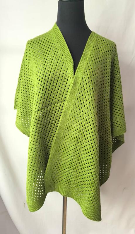 Lime green open-weave knit wrap poncho with V-neckline and ribbed hem displayed on a black mannequin