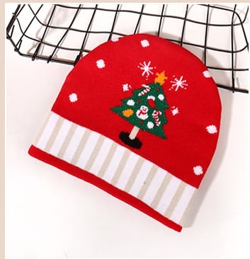Red knitted winter beanie hat featuring embroidered Christmas tree, snowflakes, and striped cuff band on white background