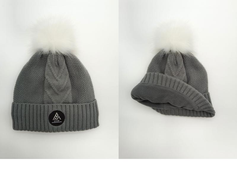 Grey cable knit winter beanie with white faux fur pom pom, shown front and interior fleece lining views