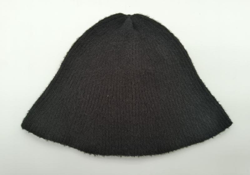 Dark charcoal ribbed knit wool beanie hat laid flat on white background showing textured rib pattern