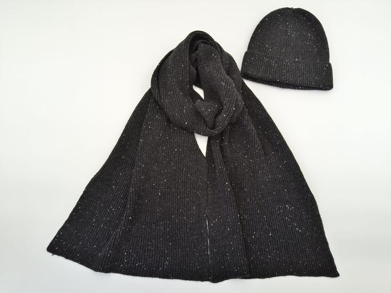 Dark charcoal ribbed knit scarf looped and matching beanie hat with white speckle pattern on white background