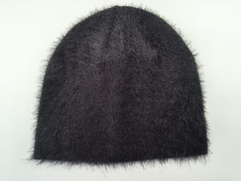 Dark charcoal fuzzy knit beanie hat with fluffy angora-style texture, laid flat on white background