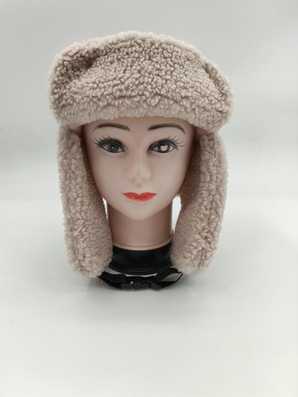 Beige sherpa fleece trapper ushanka hat with ear flaps displayed on female mannequin head, front view