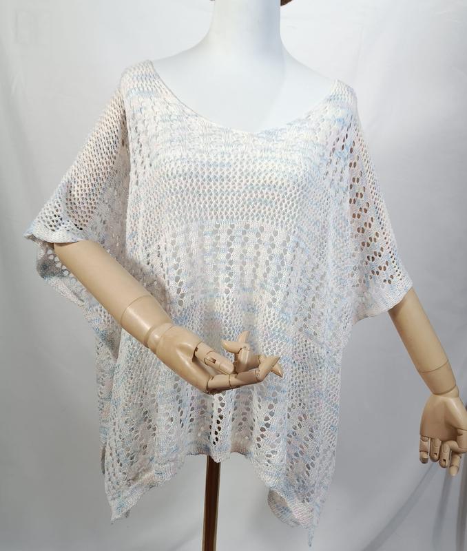 White blue multicolor open-knit crochet poncho top with short sleeves displayed on a mannequin, semi-sheer lace pattern