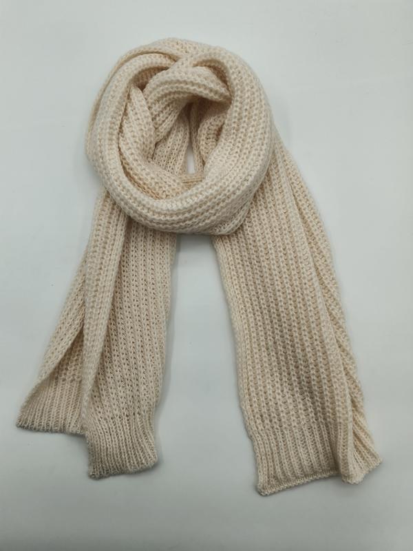 Cream chunky ribbed knit scarf looped and draped flat on white background, showing texture detail