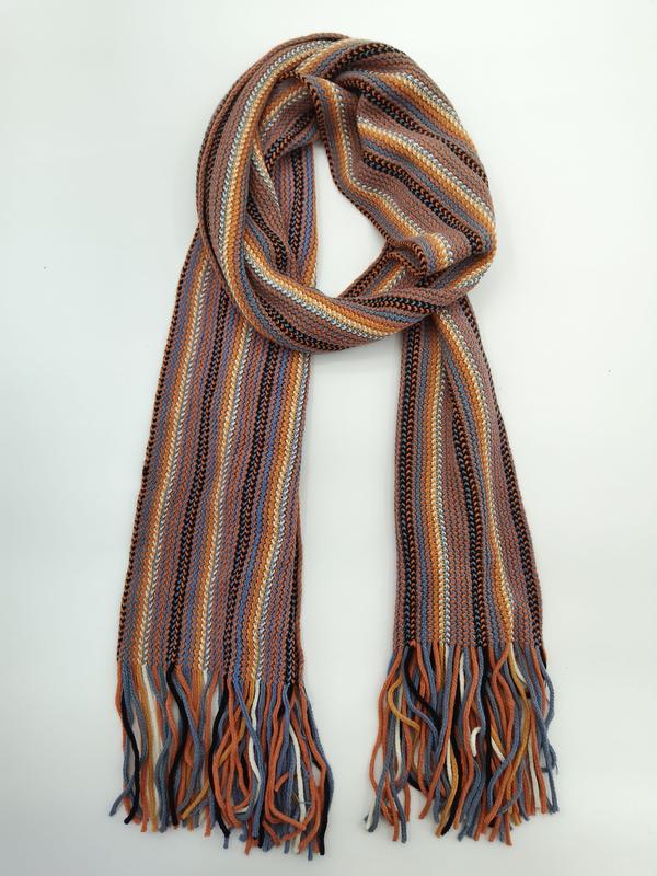 Knitted scarf with multicolor vertical stripes in rust, blue, orange, black and white, with twisted fringe ends, coiled on white background