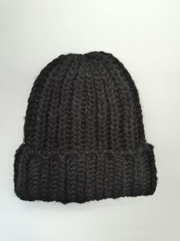 Black chunky ribbed knit beanie hat with folded cuff, photographed flat on white background, handmade style