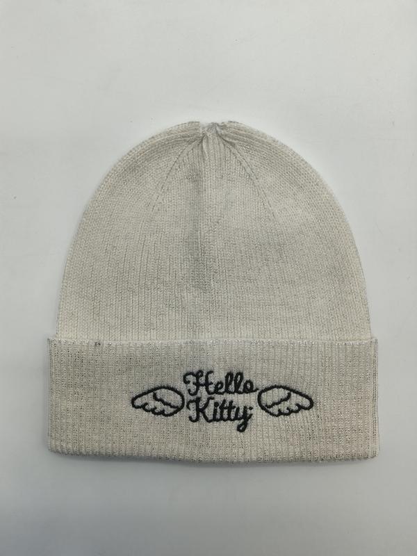 Cream ribbed knit beanie hat with Hello Kitty angel wings embroidery on folded cuff, laid flat on white background
