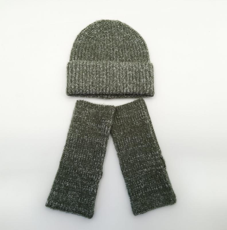 Olive green marl ribbed knit beanie hat and matching fingerless gloves set laid flat on white background