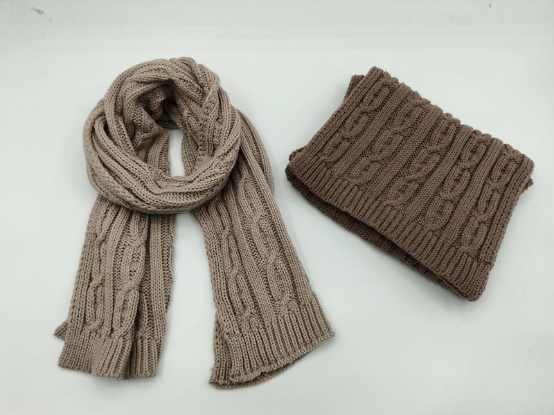 Cable knit scarf in beige and folded brown neck warmer snood on white background, winter accessories set