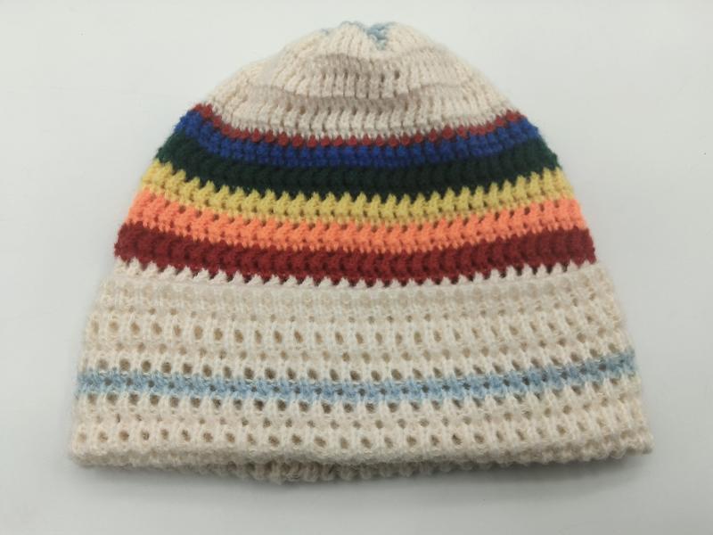 Cream knitted beanie hat with rainbow stripes in red, orange, yellow, green, blue and open mesh weave body