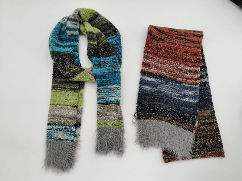 Two multicolor striped knit scarves with faux fur fringe ends, one in blue green gray tones and one in red blue brown tones