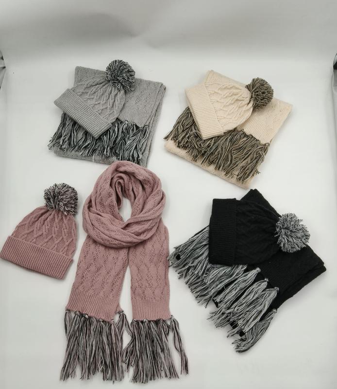 Four cable knit winter hat and scarf sets in grey, beige, pink, and black with pom pom beanies and contrast fringe tassels