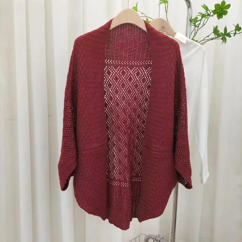 Burgundy knit open-front cardigan with diamond crochet lace back panel and 3/4 sleeves hanging on a rack