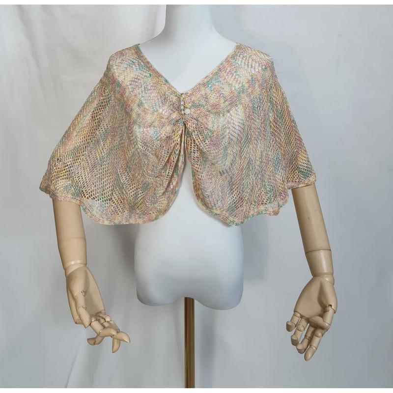 Pastel multicolor open-weave knit capelet shawl with rhinestone brooch displayed on white dress form mannequin