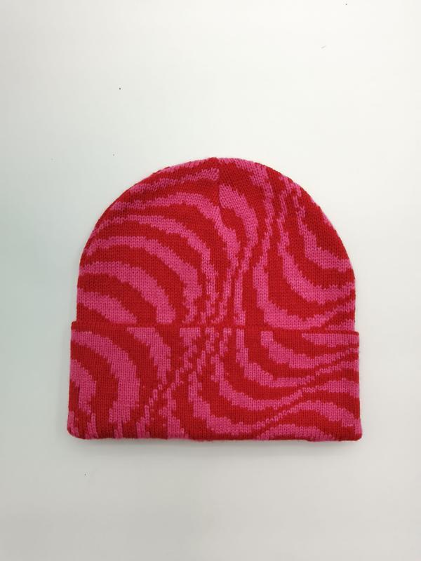 Flat lay of a pink and red zebra stripe knit beanie hat with folded cuff on white background