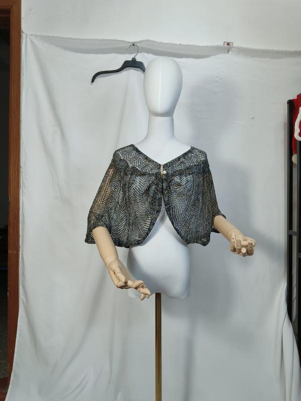 Metallic blue and gold open-weave knit capelet shawl displayed on white mannequin with pearl button closure