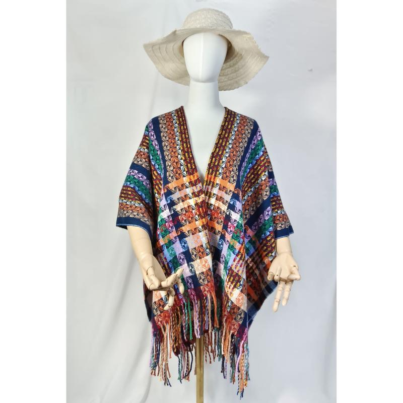 Mannequin wearing multicolor boho aztec geometric patterned fringe poncho shawl with cream floppy hat on white background