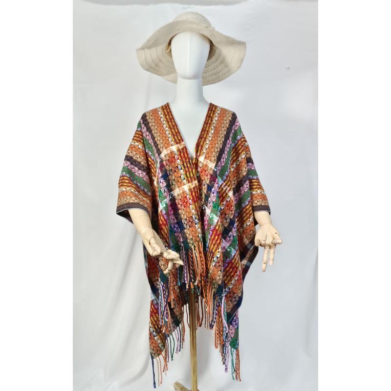 Mannequin wearing multicolor handwoven geometric diamond pattern fringe poncho wrap with wide-brim straw hat on white background