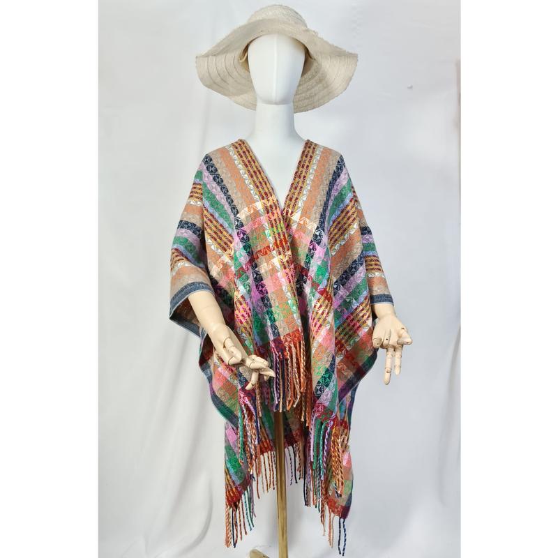 Mannequin wearing multicolor plaid woven poncho with fringe hem and wide-brim straw hat on white background