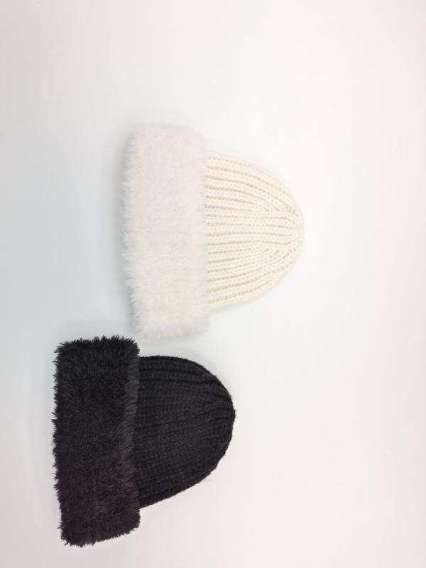 Two chunky ribbed knit beanies with fluffy faux fur folded cuff in cream white and dark charcoal, flat lay on white background