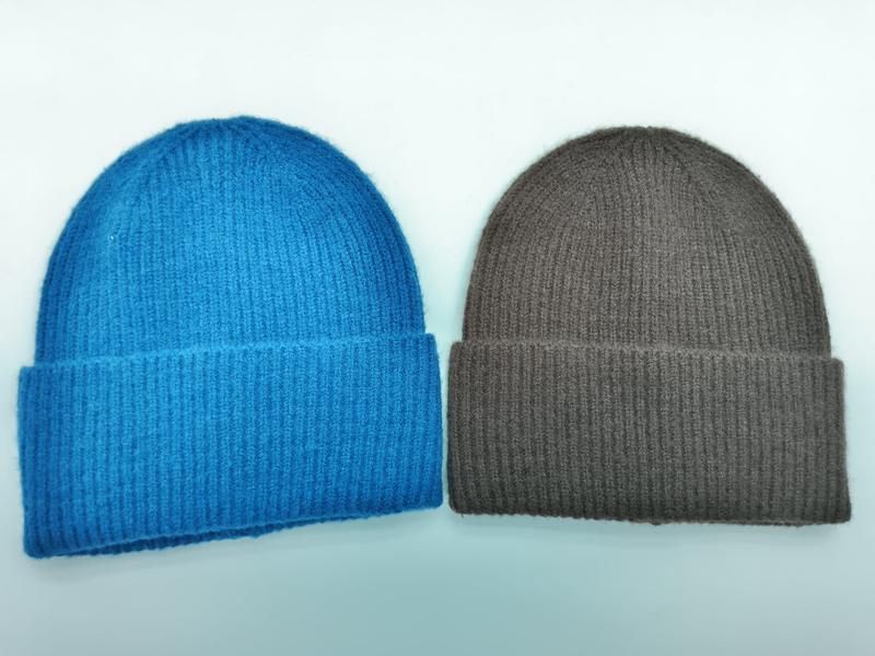 Two ribbed knit cuffed beanies side by side – one in bright blue and one in taupe brown on white background