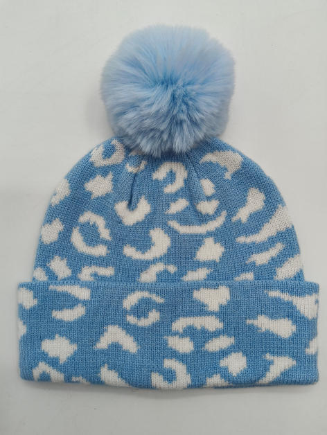 Light blue and white leopard print knitted winter beanie hat with fluffy faux fur pom pom on top