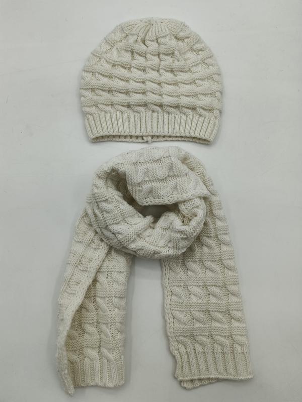 Cream cable knit winter hat and matching long scarf set laid flat on white background