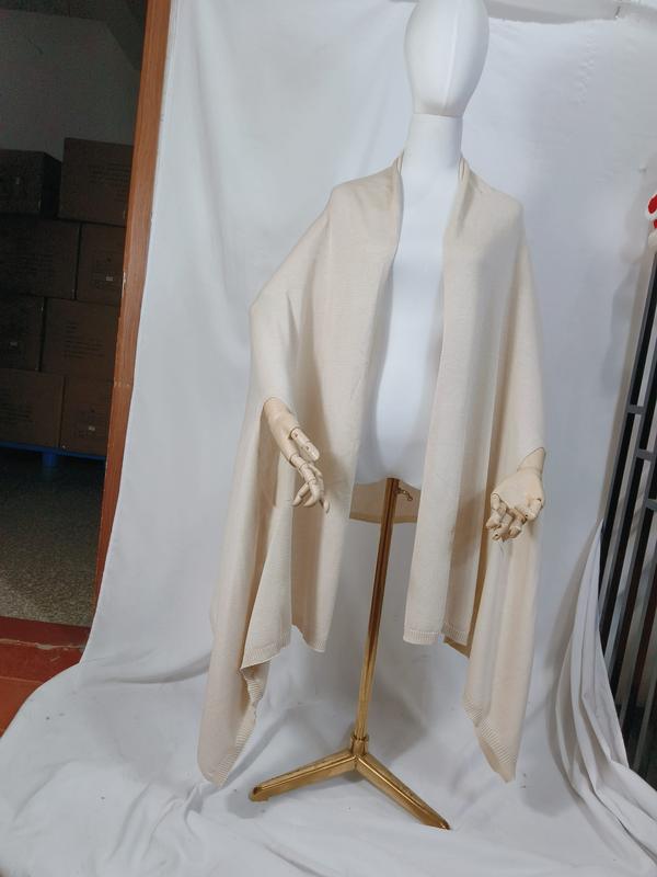 Cream ivory fine knit open-front wrap ruana cape draped on mannequin, ribbed hem edges, oversized silhouette