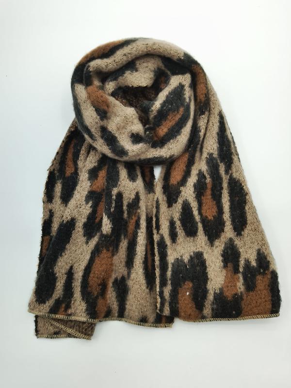 Coiled leopard print knit scarf in beige, brown, and black animal pattern, soft fluffy texture on white background