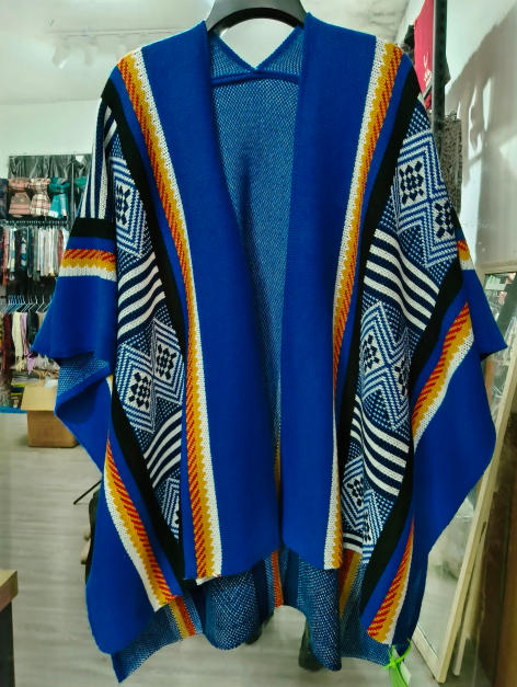 Royal blue open-front knit kimono cardigan with Aztec geometric diamond pattern in white, black, and orange stripes on hanger
