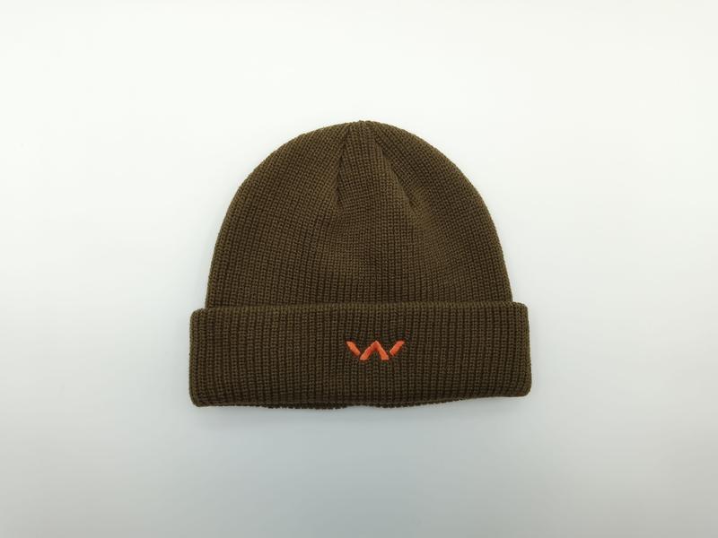 Olive green ribbed knit beanie hat with folded cuff and small orange embroidered logo, photographed flat on white background