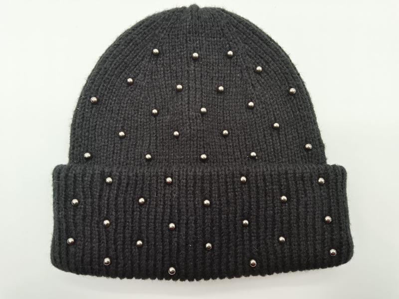 Black ribbed knit winter beanie hat with scattered silver dome studs and folded cuff, displayed flat on white background