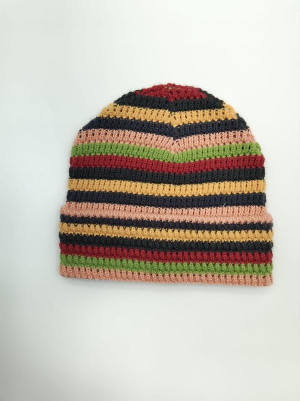 Handmade multicolor striped crochet beanie hat in pink, green, red, yellow, and black on white background