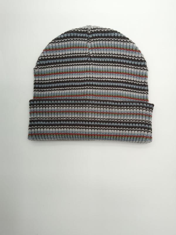 Flat lay of a ribbed knit beanie in multicolor stripes including grey, blue, brown, red, and green with a folded cuff
