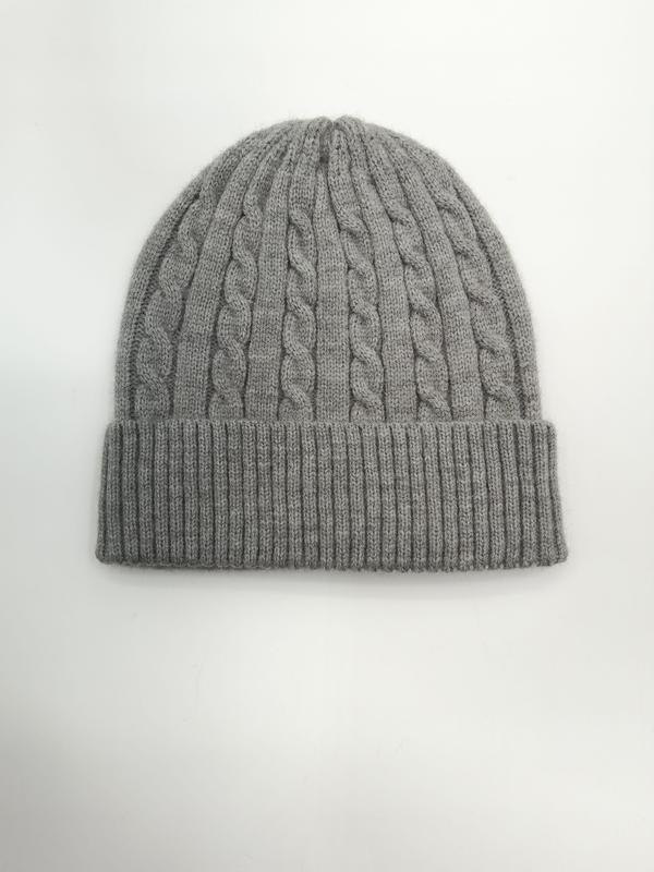 Light grey cable knit winter beanie hat with folded ribbed cuff, laid flat on white background