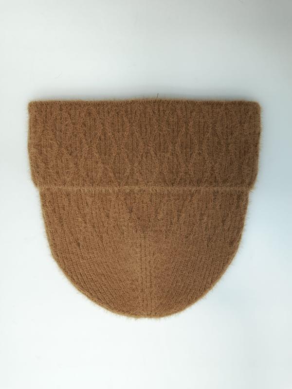 Flat lay of a camel brown fuzzy ribbed knit beanie hat with folded cuff on white background